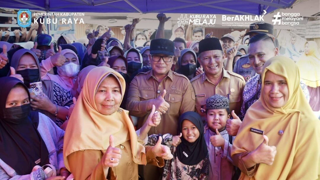 Bupati Kubu Raya Sujiwo berfoto bersama warga dan petugas dalam operasi pasar sembako di Desa Kuala Dua. (Dok. HO/Faktakalbar.id)