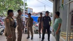 Personel Satpol PP Kabupaten Ketapang memberikan imbauan persuasif kepada pemilik usaha terkait penertiban parkir kendaraan di trotoar. (Dok. HO/Faktakalbar.id)