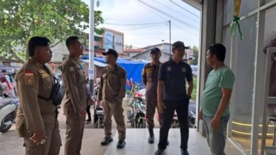 Personel Satpol PP Kabupaten Ketapang memberikan imbauan persuasif kepada pemilik usaha terkait penertiban parkir kendaraan di trotoar. (Dok. HO/Faktakalbar.id)