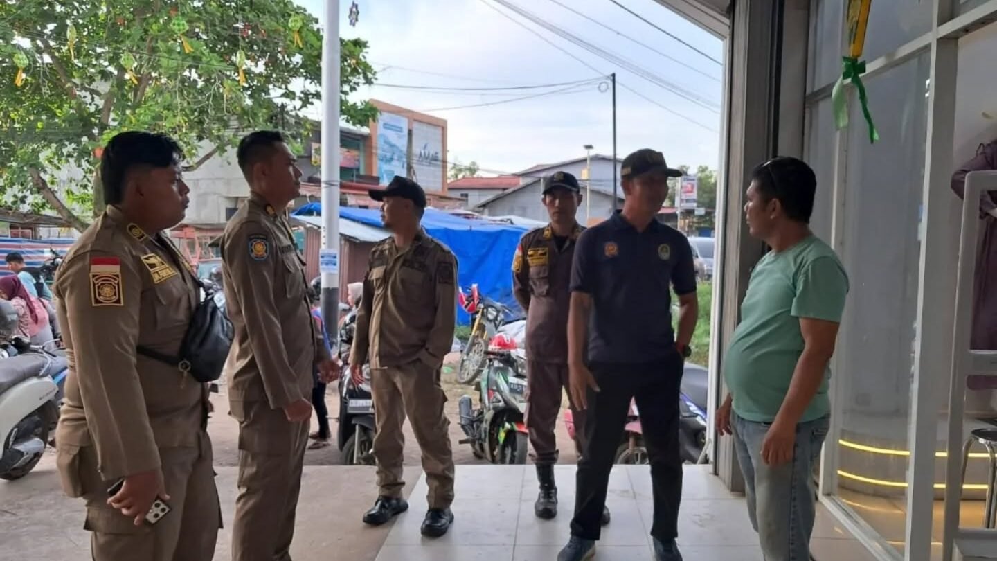 Personel Satpol PP Kabupaten Ketapang memberikan imbauan persuasif kepada pemilik usaha terkait penertiban parkir kendaraan di trotoar. (Dok. HO/Faktakalbar.id)