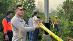 Petugas kepolisian dari Polres Kubu Raya memasang garis polisi di area lahan gambut yang terbakar guna mengamankan tempat kejadian perkara.