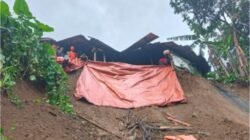 im gabungan bersama warga setempat saat bergotong royong menangani material tanah longsor yang menimpa kawasan permukiman di wilayah Kabupaten Blitar.