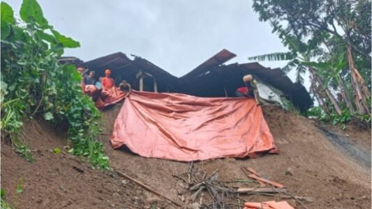 im gabungan bersama warga setempat saat bergotong royong menangani material tanah longsor yang menimpa kawasan permukiman di wilayah Kabupaten Blitar.