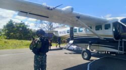 Personel bersenjata dari Satgas Yon Parako 466 saat memberikan pengawalan dan pengamanan ketat terhadap pesawat perintis yang membawa pasokan logistik di Lapangan Terbang Kenyam.