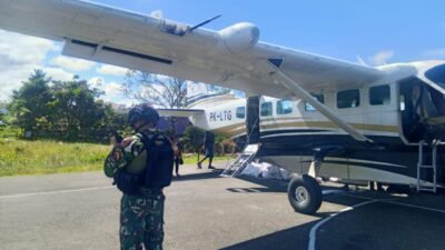 Personel bersenjata dari Satgas Yon Parako 466 saat memberikan pengawalan dan pengamanan ketat terhadap pesawat perintis yang membawa pasokan logistik di Lapangan Terbang Kenyam.