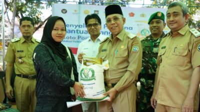 Sekda Kota Pontianak Amirullah secara simbolis menyerahkan bantuan pangan beras 10 kg kepada warga di Kelurahan Bangka Belitung Darat. (Dok. HO/Faktakalbar.id)