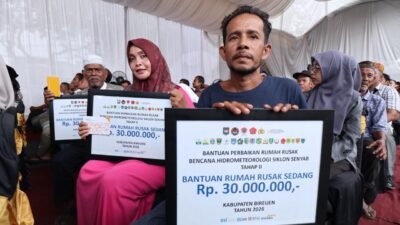 Penyerahan secara simbolis buku tabungan bantuan perbaikan rumah bagi warga terdampak bencana hidrometeorologi di Pendopo Kabupaten Bireuen, Provinsi Aceh.