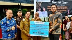 Penyerahan simbolis bantuan CSR dari Kepala Bank Kalbar Cabang Sintang Dede Hari Purnama kepada Bupati Sintang GH Bala pada kegiatan Operasi Pasar di Kelam Permai. (Dok. HO/Faktakalbar.id)