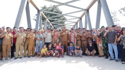 Bupati Ketapang Alexander Wilyo berfoto bersama warga dan jajaran Forkopimcam di depan Jembatan Karab yang baru diresmikan di Desa Mekar Raya. (Dok. HO/Faktakalbar.id)