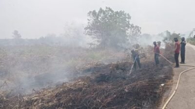 Personel kepolisian saat melakukan pemadaman di lokasi titik api kebakaran hutan dan lahan di wilayah Kecamatan Mempawah Timur, Rabu (24/3/2026).
