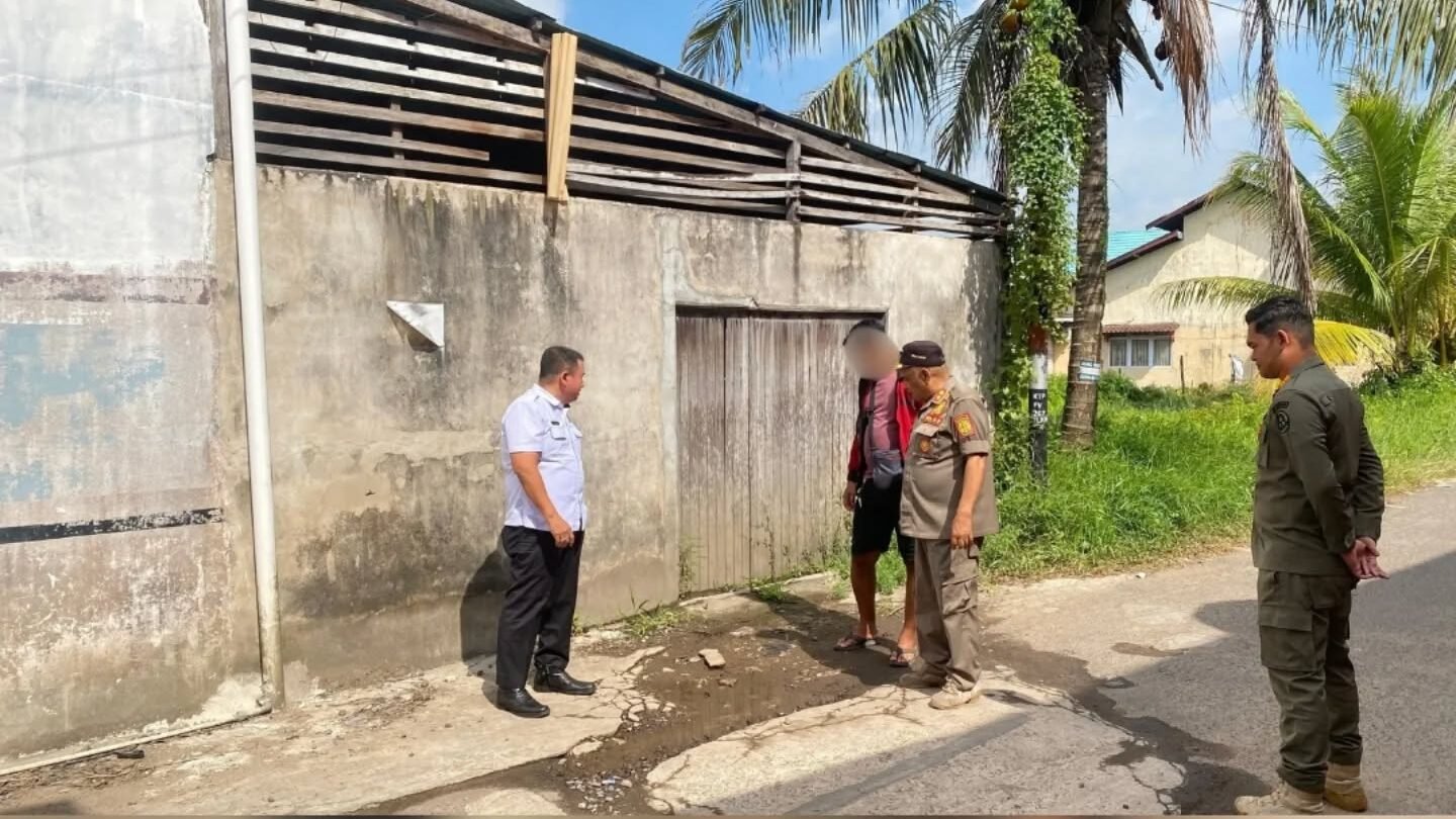 Personel Satpol PP Kabupaten Ketapang saat melakukan pengecekan lapangan dan memberikan teguran terkait pembuangan limbah air ke jalan. (Dok. HO/Faktakalbar.id)