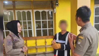 Dua petugas Satpol PP Kabupaten Ketapang sedang memberikan imbauan secara persuasif kepada seorang warga berpakaian badut Mickey Mouse di teras bangunan. (Dok. HO/Faktakalbar.id)