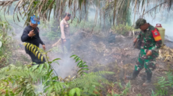 Personel Koramil 06/Selakau bahu-membahu bersama warga setempat saat berupaya memadamkan kobaran api di Desa Buduk Sempadang, Kabupaten Sambas.