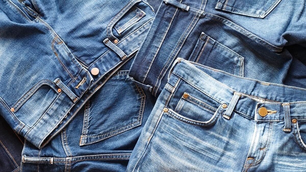 Ilustrasi tumpukan celana berbahan denim atau jeans yang memerlukan perawatan khusus agar warna dan serat kainnya tetap terjaga.