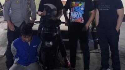 Pihak kepolisian saat mengamankan barang bukti berupa satu unit sepeda motor hasil curian usai melakukan penangkapan terhadap tersangka.