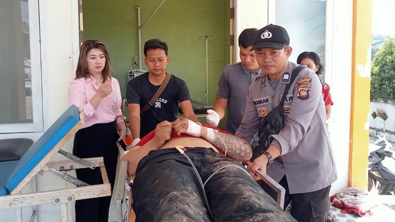 Anggota kepolisian bersama warga saat mengevakuasi korban kecelakaan lalu lintas di depan SPBU Kebadu, Kecamatan Batang Tarang, untuk mendapatkan penanganan medis.