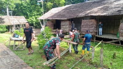 Personel Koramil 1209-07/Jgb bersama masyarakat adat saat bergotong royong memperbaiki struktur bangunan Rumah Betang di Dusun Jagoi Babang.