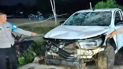 Kendaraan pikap yang mengalami kecelakaan tunggal dan terbalik ke dalam parit di pinggir jalan raya.