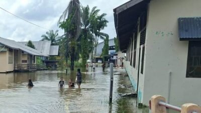 Kondisi genangan banjir luapan air sungai yang merendam jalan lingkungan dan akses fasilitas umum warga di Kecamatan Parindu, Kabupaten Sanggau.