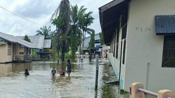 Kondisi genangan banjir luapan air sungai yang merendam jalan lingkungan dan akses fasilitas umum warga di Kecamatan Parindu, Kabupaten Sanggau.