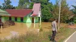Aparat kepolisian dari Polsek Toba saat meninjau langsung kondisi banjir yang merendam akses jalan dan belasan rumah warga di Desa Bagan Asam.