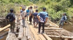 Kondisi jembatan poros di Desa Sui Antu Hulu yang ambruk akibat tergerus arus sungai saat ditinjau oleh pihak kepolisian, aparat desa, dan perwakilan perusahaan.