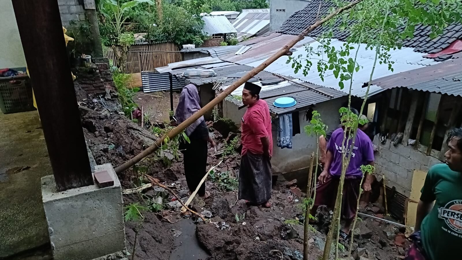 Kondisi rumah dan akses jalan yang tertutup material usai terjadi bencana tanah longsor di wilayah Desa Gunung Sari Kabupaten Lombok Barat.