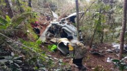 Personel gabungan dari Polri, KNKT, dan Basarnas saat mengamankan lokasi dan melakukan olah TKP puing helikopter di Desa Tapang Tingang, Kecamatan Nanga Taman.
