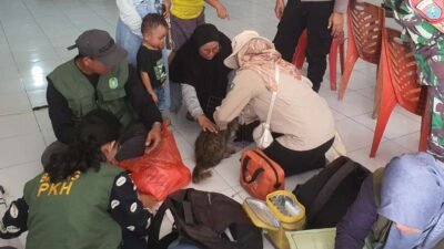 Petugas dari Dinas Perkebunan dan Peternakan Kabupaten Sanggau saat memberikan suntikan vaksin rabies kepada hewan peliharaan warga di Desa Semanget.