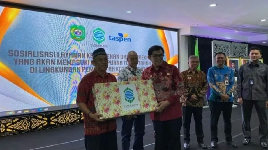 Wakil Wali Kota Singkawang Muhammadin menyerahkan cendera mata secara simbolis bersama perwakilan Bank Kalbar dan Taspen dalam sosialisasi layanan ketaspenan bagi ASN. (Dok. HO/Faktakalbar.id)