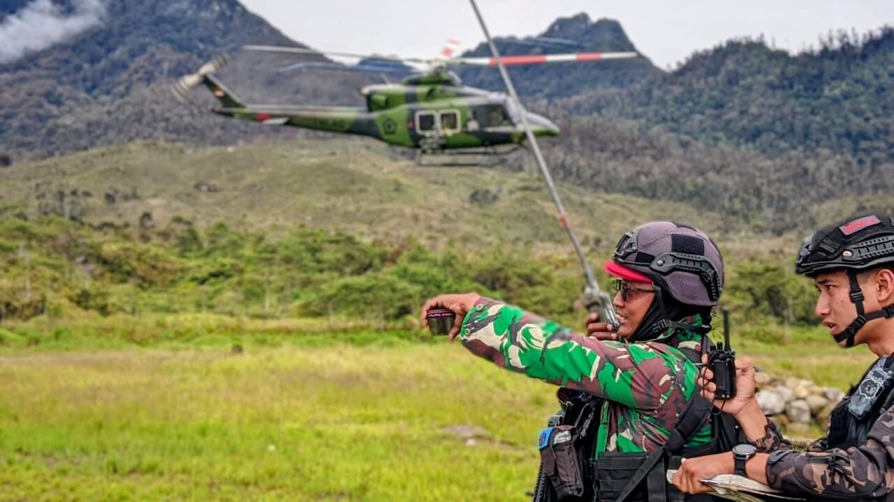 Prajurit TNI dari Satgas Yon Parako 466 Pasgat saat memandu dan mengamankan aktivitas penerbangan di landasan perintis Distrik Sinak, Provinsi Papua Tengah.