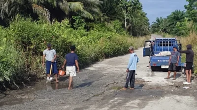 Puluhan warga Desa Sekabuk bergotong royong secara swadaya memperbaiki dan menambal ruas jalan yang rusak menuju kawasan Sederam.