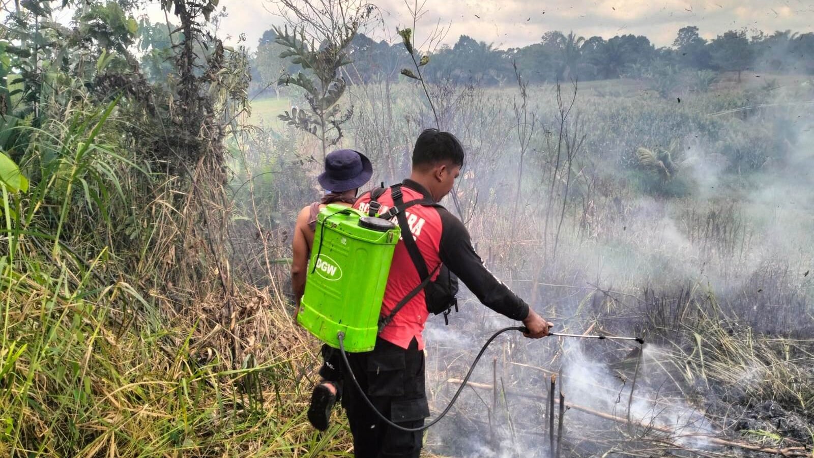 Personel Polsek Parindu saat melakukan pengecekan langsung ke lokasi lahan pertanian milik warga usai terdeteksi titik api melalui aplikasi Lancang Kuning.