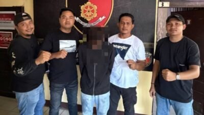 Personel kepolisian dari Unit Jatanras Polres Mempawah bersama satu orang terduga pelaku pencurian (DA) berkaos hitam yang wajahnya diburamkan, berdiri bersama di depan kantor dengan latar belakang spanduk dan pintu.