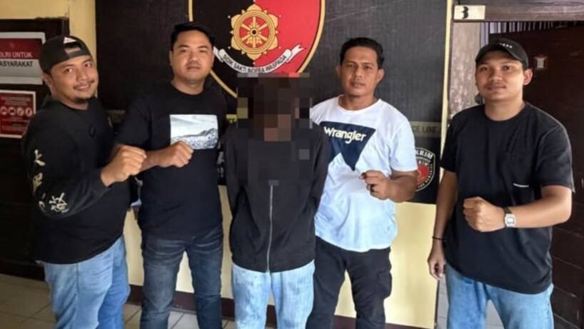 Personel kepolisian dari Unit Jatanras Polres Mempawah bersama satu orang terduga pelaku pencurian (DA) berkaos hitam yang wajahnya diburamkan, berdiri bersama di depan kantor dengan latar belakang spanduk dan pintu.