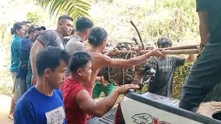 Rombongan warga dan tim gabungan saat bergotong royong memikul komponen mesin helikopter yang jatuh di medan terjal Desa Tapang Tingang, Sekadau.
