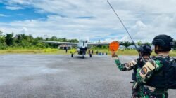 Prajurit Satgas Yon Parako 466 Pasgat melakukan pengamanan perimeter saat proses bongkar muat logistik dari pesawat perintis di Distrik Manggelum.