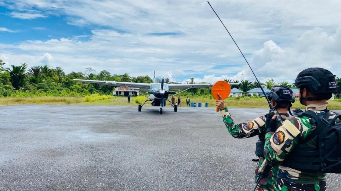 Prajurit Satgas Yon Parako 466 Pasgat melakukan pengamanan perimeter saat proses bongkar muat logistik dari pesawat perintis di Distrik Manggelum.