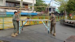 Tiga anggota Satpol PP Kota Pontianak sedang memindahkan meja kayu milik pedagang kaki lima saat penertiban di kawasan Waterfront. (Dok. HO/Faktakalbar.id)