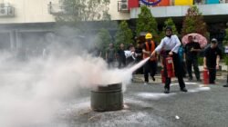 Seorang Karyawan saat mempraktikkan pemadaman api menggunakan alat pemadam ringan dalam kegiatan simulasi kebakaran di area parkiran hotel.