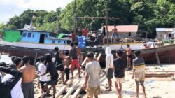 Sejumlah warga pesisir bergotong royong menurunkan bantuan satu unit genset dari PT Dharma Inti Bersama (PT DIB) dari atas kapal motor bersandar. (Dok. HO/Faktakalbar.id)