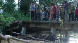 Bupati Sambas Satono didampingi Dandim 1208/Sambas memantau kondisi struktur Jembatan Berkemajuan yang miring setelah diterjang arus sungai deras.