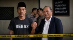 Ilustrasi AI: Sujono (SJ) mengenakan kaus bertuliskan “BEBAS” berjabat tangan dengan kuasa hukumnya usai dibebaskan