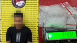 Tersangka pengedar narkotika berinisial R saat diamankan oleh petugas kepolisian beserta barang bukti berupa paket sabu siap edar.