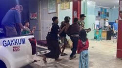 Personel kepolisian saat membantu proses evakuasi medis darurat seorang pasien lansia menuju ruang IGD rumah sakit menggunakan armada mobil patroli.