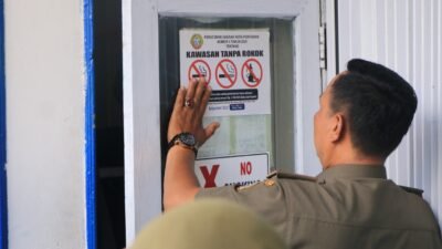 Tim Satgas Kawasan Tanpa Rokok (KTR) tengah menempelkan tanda larangan merokok sebagai implementasi Perda Nomor 4 Tahun 2025 tentang KTR.